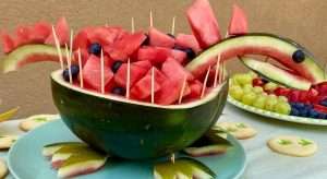 Wassermelone halbiert und als Dinosaurier gestaltet und mit Wassermelonenstücke gefüllt