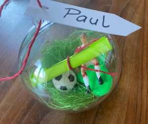 Einladung zum Fußball Kindergeburtstag - eine durchsichtige Plastikkugel mit Dekograß, einem kleinen Plastikfußballer und dem Namenskärtchen