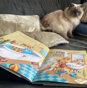 Buchseite vom Kinderbuch-Tipp Wimmelbuch mit dem Badezimmer und Katze sitzt immer noch daneben