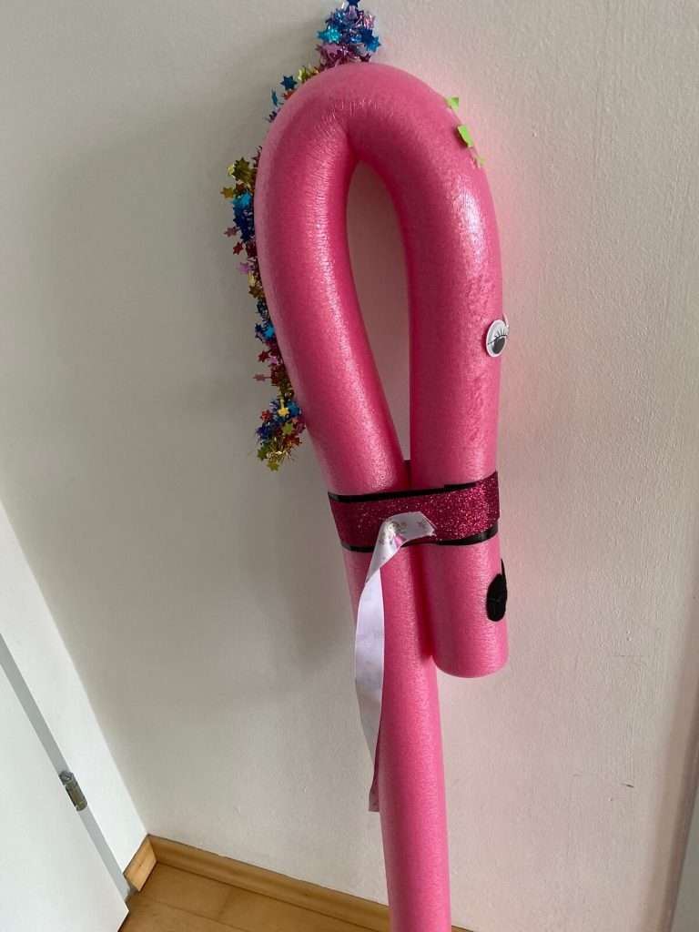 unsere Bastelaufgabe zum Einhorn Geburtstag - hier steht ein rosa Einhorn aus einer Schwimmnudel gebastelt, das man als Steckenpferd verwenden kann