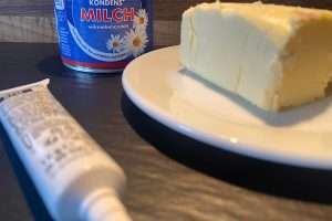 Butter und Lebenmittelfarbe und im Hintergrund die Kondensmilch-Dose
