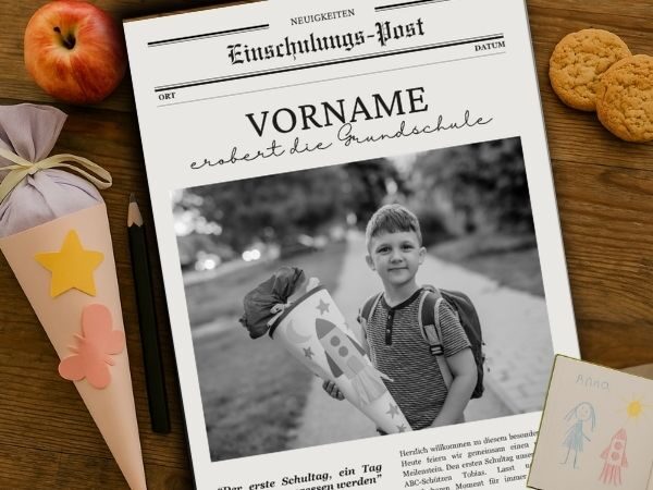Einschulungszeitung mit dem Cover liegt auf einem Tisch umrahmt von einer Schultüte und einem Apfel