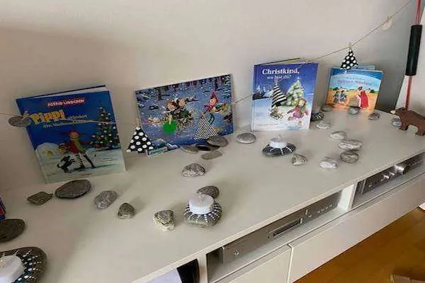steine die einen Adventsweg darstellen mit Weihnachtsbüchern im Hintergrund