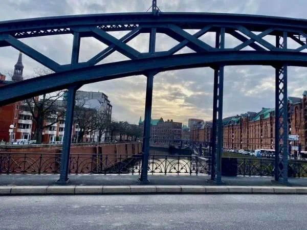 Blick auf die Elbbrücke in Hamburg bei Sonnenuntergang, mit Stadtgebäuden im Hintergrund, ideal für Familienausflüge in Hamburg.