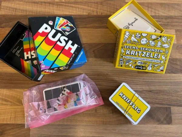Reisespiele wie Push und Sechs-Sekunden-Kritzelei platzsparend verpackt, Kartenspiel mit Gummiband und in einem ZIP-Beutel.