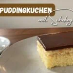 Beitragsbild mit dem Titel: Puddingkuchen mit Schokoglasur und einem Stück Kuchen auf einem Teller neben einer Tasse auf einem Tisch