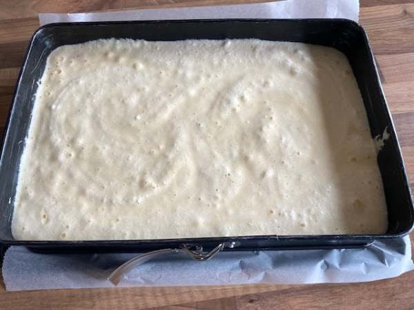 Der glatt gestrichene Kuchenteig auf dem Backblech, bereit f&uuml;r den Ofen.