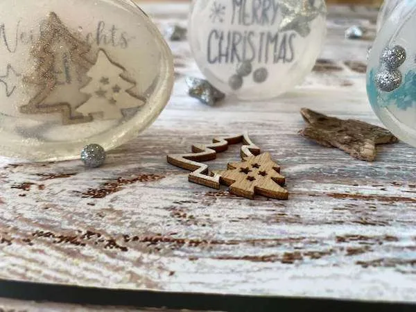 3 Seifen aufgestellt auf einem Holzuntergrund mit kleinen Weihnachtsdekoelementen