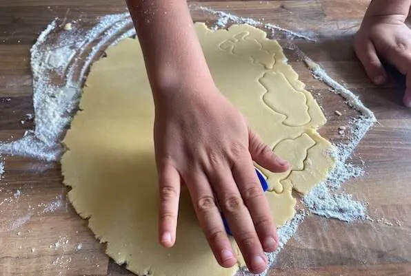 Eine Hand die aus einem Keksteig Formen aussticht