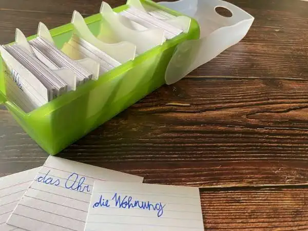 offener Karteikasten mit Karteikarten die davor liegen