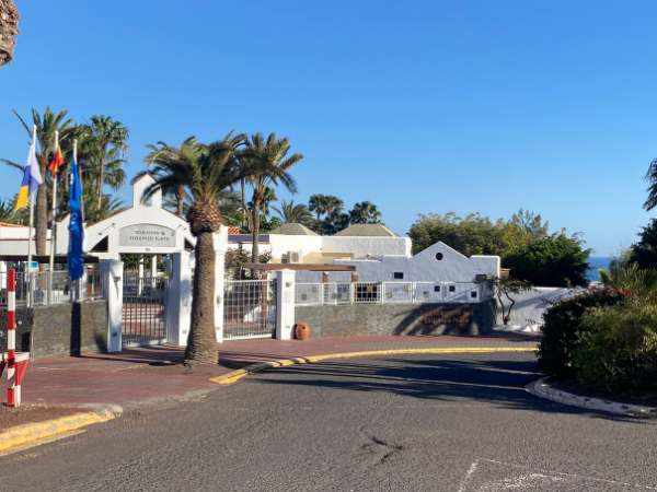 Fuerteventura mit Kindern: Bunte Hotelanlage mit Palmen, blauer Himmel und entspannte Urlaubsatmosph&auml;re, ideal f&uuml;r Familienurlaub auf der Kanareninsel.