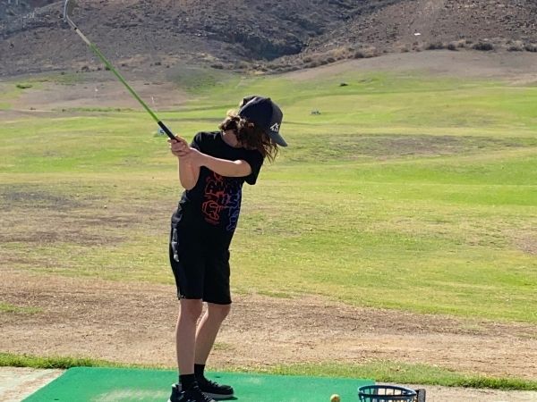 Kind beim Golfspielen
