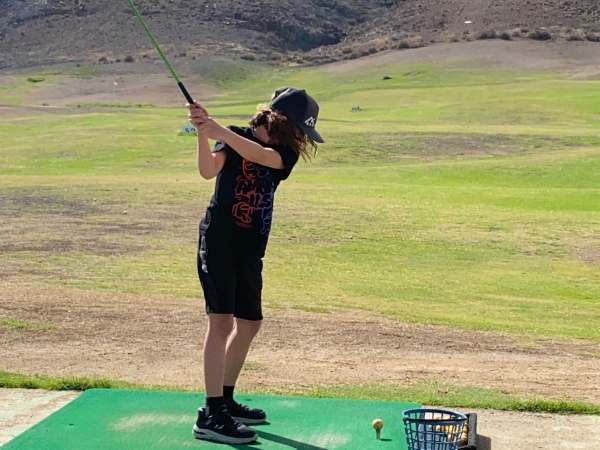 Kind beim Golfspielen auf Fuerteventura mit Kindern, Familienurlaub, Outdoor-Aktivit&auml;ten, Naturerlebnis, kindgerechte Freizeitgestaltung, sonniges Reiseziel, Familienabenteuer, Urlaub mit Kindern,.