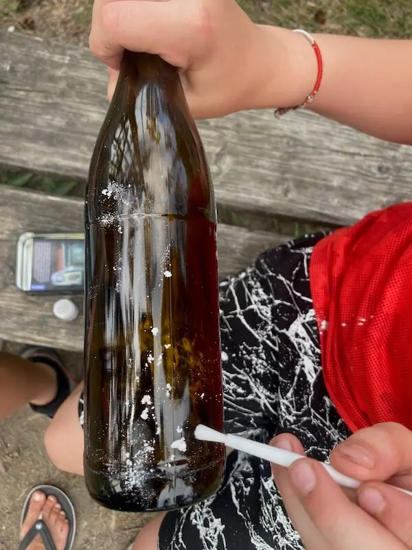 Ein Kind das gerade einen Fingerabdruck von einer Flasche nimmt