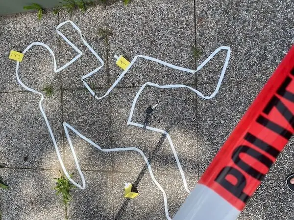 Umriss eines Menschen auf einem Boden mit einem Abspressband und Zahlen 