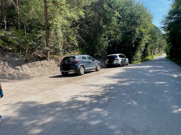 2 Autos, die neben der Straße am Parkplatz für den Klettersteig Sitz stehen