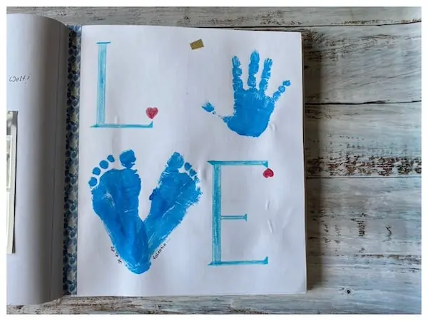 Ein Handabdruck als Buchstabe o und zwei Fußabdrücke als v für das Worte Love