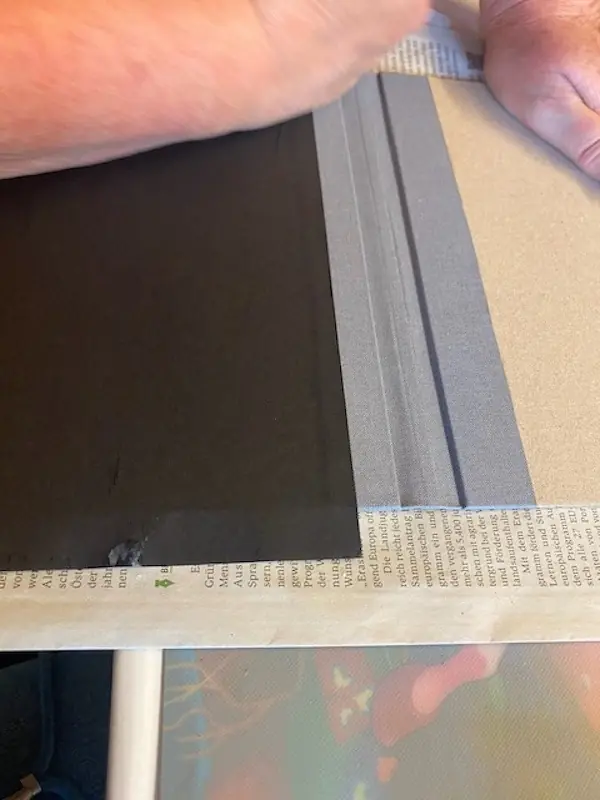 über den Steg wird gerade ein schwarzes Papier geklebt für das Cover