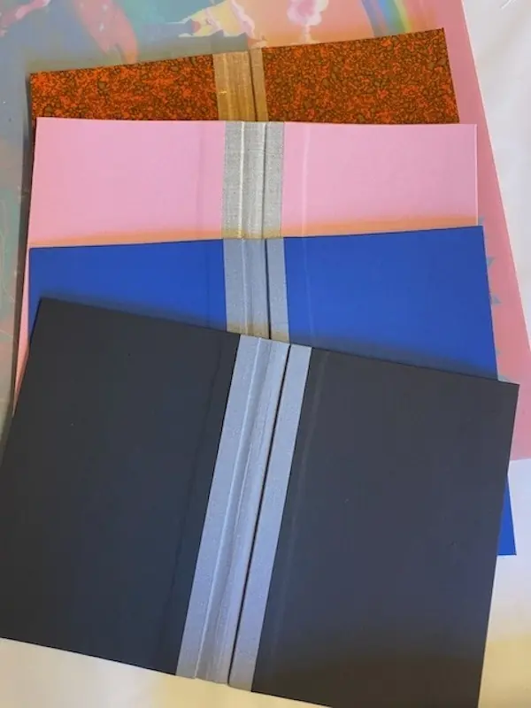 verschiedene Cover in unterschiedlichen Farben von schwarz über blau und rosa