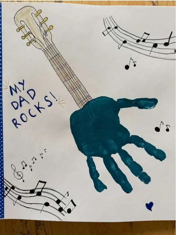 Bunte Gitarre mit Kinderhand gestaltet, musikalisches Motiv für Kinder, kreative Eltern-Kind-Aktivität, Musik und Kunst, DIY Geschenkidee für Väter, Eltern-Kind-Beschäftigung.