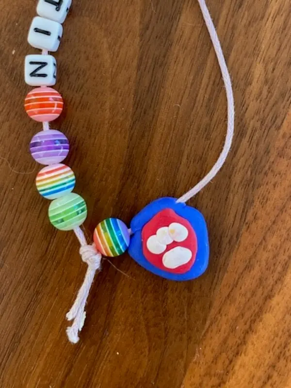 Kette mit Perlen mit einem selbst gemachten Anhänger mit einem Pfotenabdruck drauf
