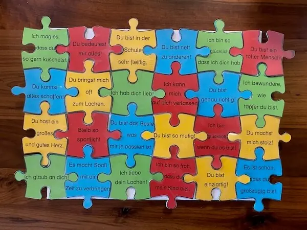 Puzzleteile mit Texten mit guten Eigenschaften des Kindes - eine kreative Füllung für den Adventskalender als Inhalt