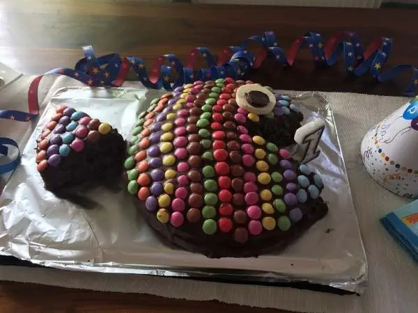 Bunter Schokoladenkuchen in Form eines Fisches mit bunten Streuseln, ideal für Kindergeburtstag, festliche Feier, Partydekoration, süßer Leckerbissen, festliche Atmosphäre, Geburtstag, Kinderparty, fe.