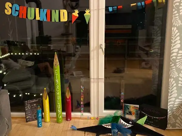 Deko für den ersten Schultag: mit einer Schriftgiralnde am Fenster und riesigen Bleistiften am Boden