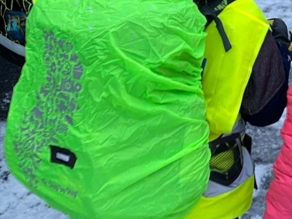 Regenschutz auf einer Schultasche in grüner Leuchtfarbe