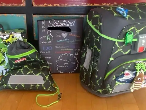 Schultasche mit Turnsack und der Meilensteintafel