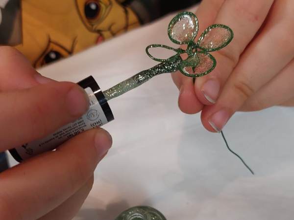 auf eines der gedrehten Blätter wird der Nagellack mit dem Pinsel aufgetragen