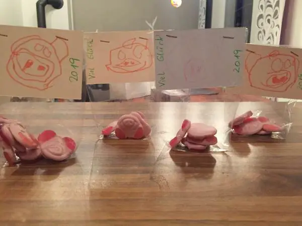 4 Zellophantüten mit essbaren Schweinchenköpfen und einem selbst gemalten Schwein als Verschluss