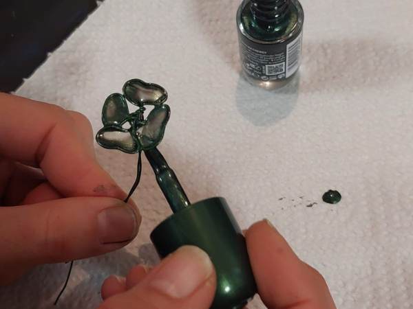 mit dem Pinsel wird der Nagellack auf dem Kleeblatt aufgetragen