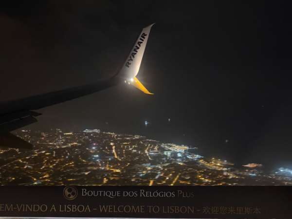 Flugzeugflügel in der nacht über Lissabon