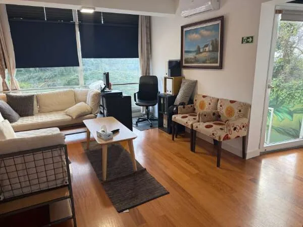 Raum im Hostel mit Couch und Fensterblick in den Garten