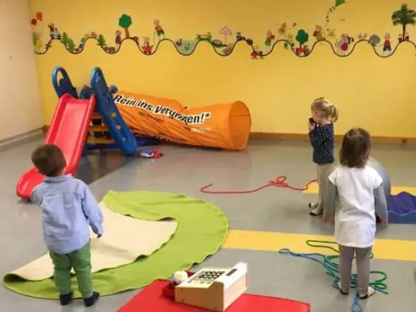 drei Kinder die in einem großen Partyraum tanzen