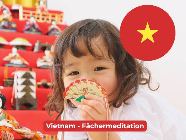Eine vietnamesische Flagge mit einem Kind im Hintergrund, das einen kleinen Fächer in der Hand hält