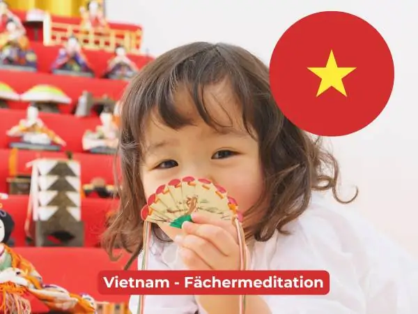 Eine vietnamesische Flagge mit einem Kind im Hintergrund, das einen kleinen Fächer in der Hand hält