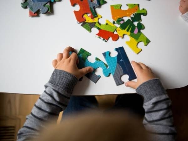 Kinderhände, die gerade ein Puzzle bauen als Konzentrationsübung