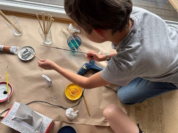 Farbenfrohes Bastelprojekt mit einem Kind, das kreative Ideen mit Draht, Baumwolle und Bastelmaterialien umsetzt, ideal für Bastelspaß und DIY-Aktivitäten für Kinder.