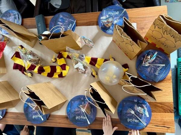 Tischdeko vom Harry Potter Party mit Tellern, einem Gryffindor Schal und Mitgebseltüten