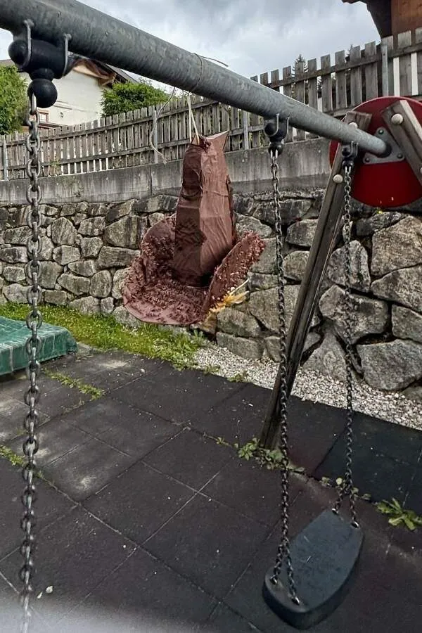 Pinata in form eines sprechenden Hutes an einem Schaukelstange festgemacht
