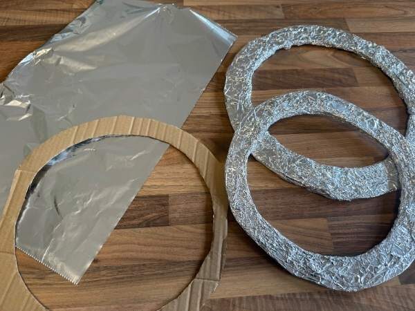 Ringe mit silberner Alufolie verkleidet und ein Kartonring noch ohne Folie