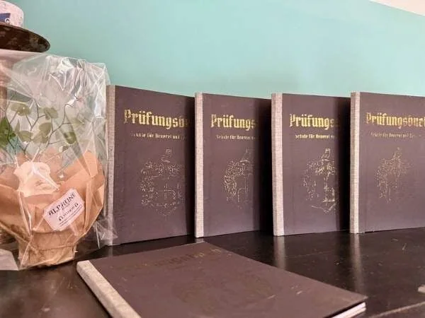 Prüfungshefte für das Staatsexamen, Lernmaterialien für angehende Lehrer und Prüflinge, auf einem Tisch mit Dekoration, geeignet für Studium und Weiterbildung im pädagogischen Bereich.