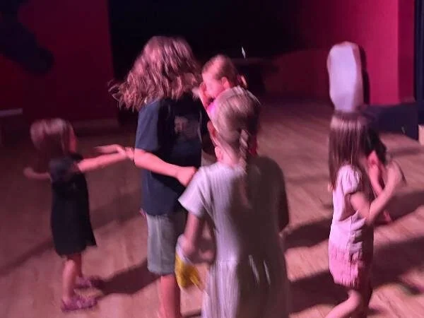 Fröhliche Kinder tanzen gemeinsam bei einer Kinderskifreizeit, Freude und Spaß stehen im Mittelpunkt, ideal für Eltern, die Kinderskifahrten und Familienaktivitäten suchen.