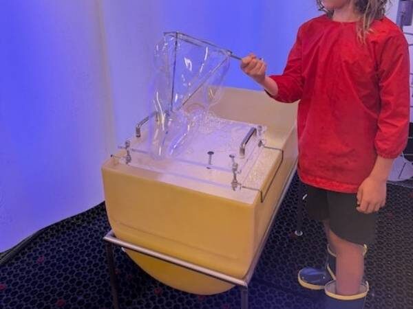 Kind beim Spielen mit Seifenblasen