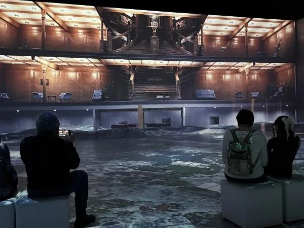 Ein dunkles, stilvolles Eistheater mit Wasser und drei Zuschauer, die das außergewöhnliche Erlebnis genießen. Perfekt für Erlebnisse im Winter in Österreich.