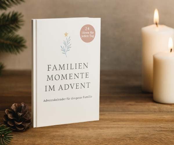 Buch stehend auf einem Regal mit Kerzen im Hintergrund. Das Buch hat den Titel "Familienmomente im Advent"
