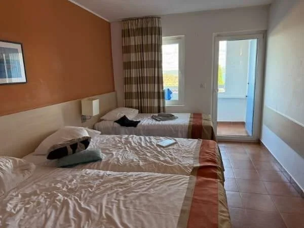 Hotelzimmer mit 3 Betten und Blick Richtung Balkon