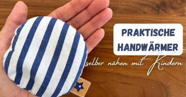 eine Hand mit einem kleinen Handwärmer blau weiß gestreift mit dem Titel: praktische handwärmer selber nähen mit Kindern